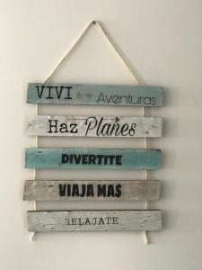 a group of wooden signs hanging on a wall at Belvedere in Puerto Madryn