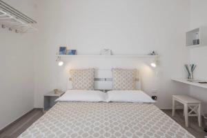 a white bedroom with a large bed and a desk at Guest House Villa Antica in Salerno