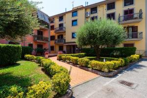 apartamentowiec z krzakami i drzewem na dziedzińcu w obiekcie Emozioni D'artista w mieście Salerno