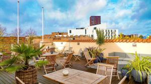 un patio con tavoli e sedie sul tetto di City Hotel Nattergalen a Odense