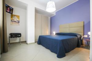 - une chambre bleue avec un lit et une chaise dans l'établissement Finestre d'Occidente, à Trapani