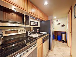 a kitchen with a stove and a stainless steel refrigerator at Timberline Condominums Studio Loft Standard Unit 301 in Snowmass Village +6 photos