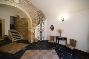 a room with a staircase and a stone wall at Baroque Modica in Modica