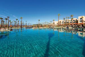 - une grande piscine avec des palmiers dans un complexe dans l'établissement Hotel Riu Palace Tikida Taghazout - All Inclusive, à Taghazout