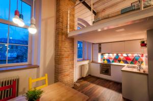 cocina con mesa de madera y pared de ladrillo en Gami Ex-Factory Lofts, en Liubliana