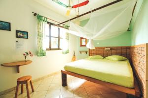 Schlafzimmer mit einem Bett mit Moskitonetz in der Unterkunft Casa Strela B&B Tarrafal in Tarrafal