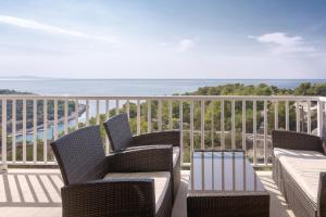 balcone con sedie, tavolo e vista sull'oceano di Sunlight Apartment Hvar a Hvar