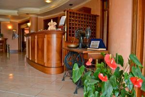 a lobby with a large room with a clock and flowers at Hotel Valle Rossa in San Giovanni Rotondo