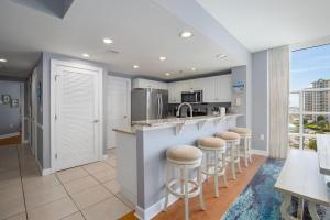 a kitchen with a bar with stools and a counter top at Sterling Shores V in Destin