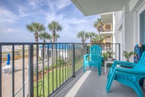 a balcony with two blue chairs and the ocean at Sea Oats in Fort Walton Beach