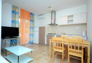 a kitchen with a table and a dining room at Apartments and Rooms Stipe in Podstrana