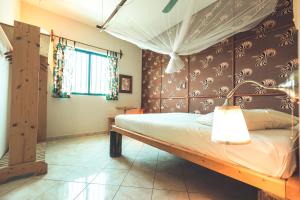 a bedroom with a bed with a wooden headboard at Casa Strela B&B Tarrafal in Tarrafal