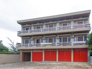 un edificio con puertas rojas y garaje rojo en OYO Life 3365 Griya Nusantara Syariah, en Bandar Lampung