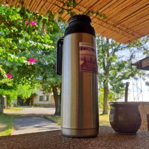 a thermos is sitting on a table with a vase at Tranquilo entorno campestre in Treinta y Tres