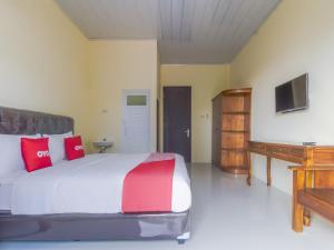 um quarto com uma cama grande e almofadas vermelhas em OYO Life 3365 Griya Nusantara Syariah em Bandar Lampung