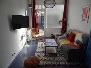 a living room with a couch and a tv at Studio L'AZULEJOS in Le Havre