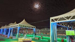 a stage with blue and white structures at night at Qasr Alshamal Hotel in Arar