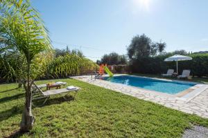 un patio trasero con piscina y parque infantil en Villa Renata, en Barbati