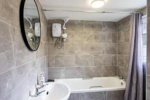 een badkamer met een wastafel en een bad bij FREE PARKING -2 Bed Apartment, 7mins to City Centre - by StirkMartin in Cardiff