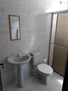 a bathroom with a toilet and a sink at Condomínio Villagio de Maranduba VII - Praia do Sapê in Ubatuba +27 photos