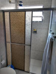 a shower with a glass door in a bathroom at Condomínio Villagio de Maranduba VII - Praia do Sapê in Ubatuba