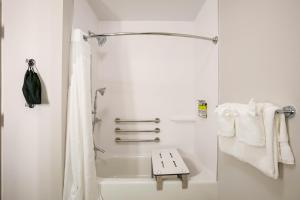ein Badezimmer mit einer Dusche, einer Badewanne und Handtüchern in der Unterkunft Holiday Inn Express & Suites Jacksonville - Town Center, an IHG Hotel in Jacksonville