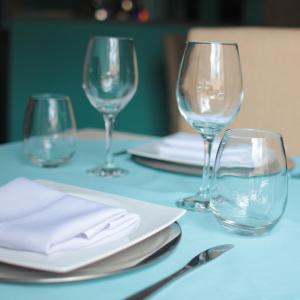 una mesa con tres copas de vino y platos en ella en Samsara Hotel Salta en Salta