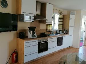 a kitchen with white cabinets and a stove top oven at Hausboot MS Donautal in Neuhaus