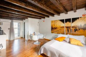 a bedroom with a bed and a painting on the wall at Just Here apartments - La mansarda in Bari