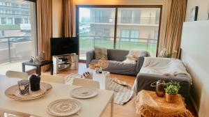 a living room with a couch and a table at Ruim, lichtrijk appartement met groot terras uitstekend gelegen in De Panne in De Panne