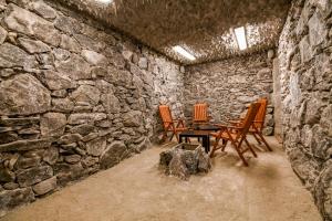 a room with three chairs and a table in a stone wall at Pensiunea Casa Nostalgia in Bran