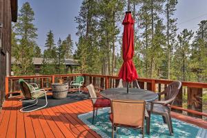 a deck with a table and chairs and an umbrella at Walk to Town: Updated Frisco Cabin w/ 2 Decks! in Frisco