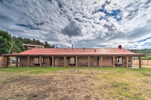une ancienne maison avec un toit rouge sur un champ dans l'établissement Rustic Ranch Retreat with Yard 16 Mi to Ski Apache!, à Ruidoso