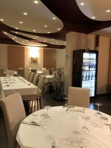 a restaurant with white tables and chairs with wine glasses at Locanda Damaro in Vicenza