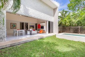 un patio trasero de una casa con piscina y una casa en Casa de 4 habitaciones con alberca privada!, en Cancún
