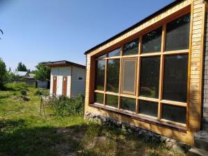 una casa con ventanas grandes en un lateral en Family FunHouse, en Vorontsovskoye