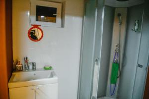 a bathroom with a shower next to a sink and a sink at Family FunHouse in Vorontsovskoye