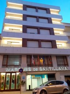 un edificio con un coche aparcado delante de él en Hotel Marqués de Santillana en Torrelavega