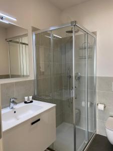 uma casa de banho com uma cabina de duche em vidro e um lavatório. em Locanda Damaro em Vicenza