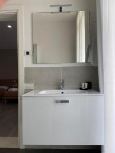 y baño con lavabo blanco y espejo. en Locanda Damaro, en Vicenza