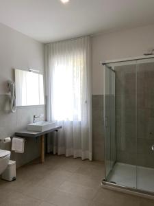 y baño con ducha acristalada y lavamanos. en Locanda Damaro, en Vicenza