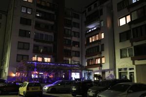 a parking lot with cars parked in front of buildings at night at Apartman UNA Travnik in Travnik