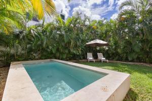 una piscina en un patio con sombrilla en Casa de 4 habitaciones con alberca privada!, en Cancún