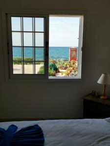a bedroom with a window looking out at the ocean at Anastasia Apartment in Ayia Marina