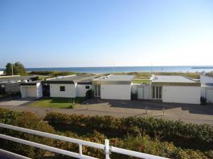 a row of houses with the ocean in the background at Inselglueck in Burgtiefe auf Fehmarn 