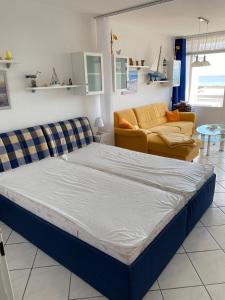 ein großes Bett in einem Zimmer mit Sofa in der Unterkunft Inselglück in Burgtiefe auf Fehmarn 