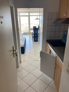 a kitchen with a tiled floor and a open door at Inselglueck in Burgtiefe auf Fehmarn  +4 photos