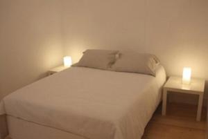 um quarto com uma cama branca com duas mesas de cabeceira em Se de Lisboa I em Lisboa
