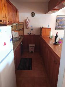 kuchnia z drewnianymi szafkami i białą lodówką w obiekcie Apartamento Neptuno playa 06 w mieście Puerto de Santiago