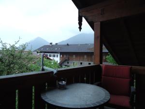 a table on a balcony with a view of mountains at Ferienwohnung Wingen in Bad Feilnbach